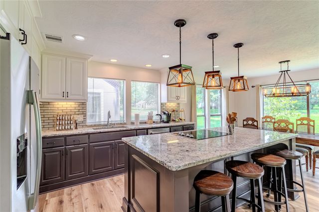 a kitchen with granite countertop a sink and a wooden floor