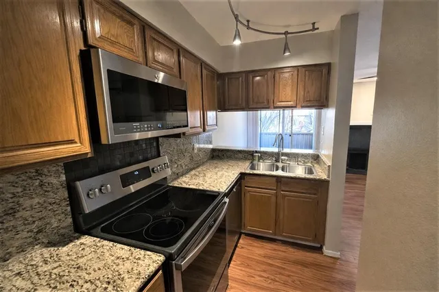 a kitchen with stainless steel appliances a stove sink and microwave