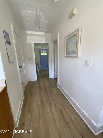 a view of a hallway with wooden floor and stairs