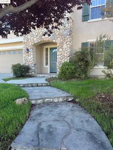 a view of a house with a yard and potted plants