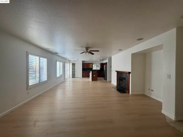 a view of an empty room with a fireplace and a window