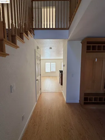 a view of a hallway with entryway wooden floor and windows