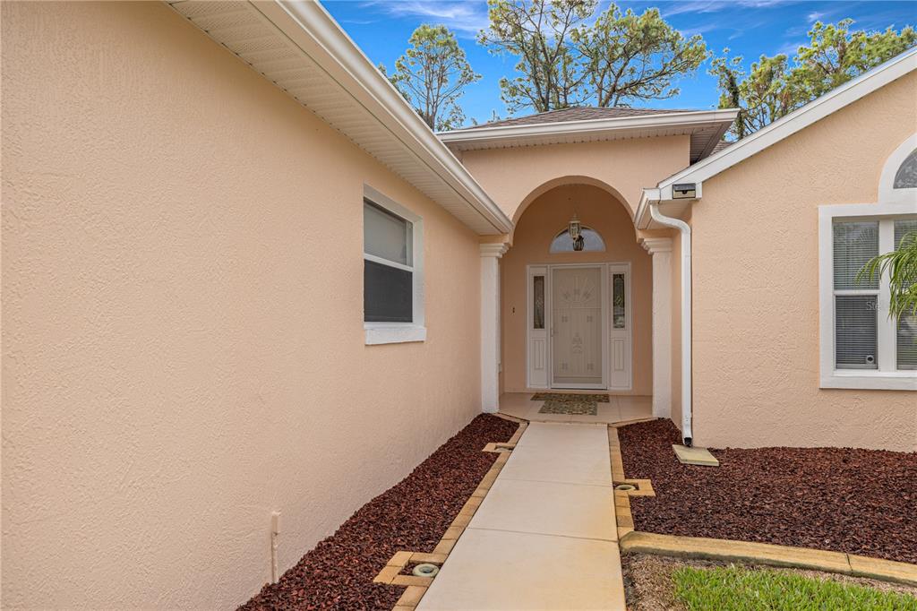 11298 Southwest 73rd Circle Ocala, FL 34476 - Photo 2 of 14 a front view of a house with a garden
