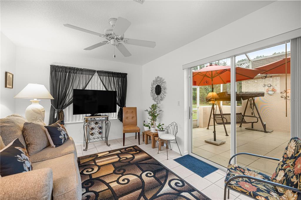11298 Southwest 73rd Circle Ocala, FL 34476 - Photo 7 of 14 a living room with furniture a flat screen tv and a floor to ceiling window
