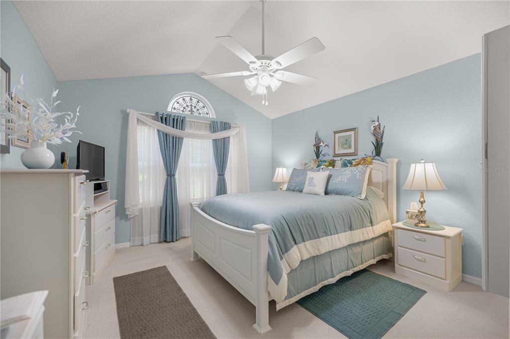 11298 Southwest 73rd Circle Ocala, FL 34476 - Photo 8 of 14 a bedroom with a bed and a chandelier