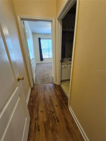 a view of a hallway with wooden floor and staircase