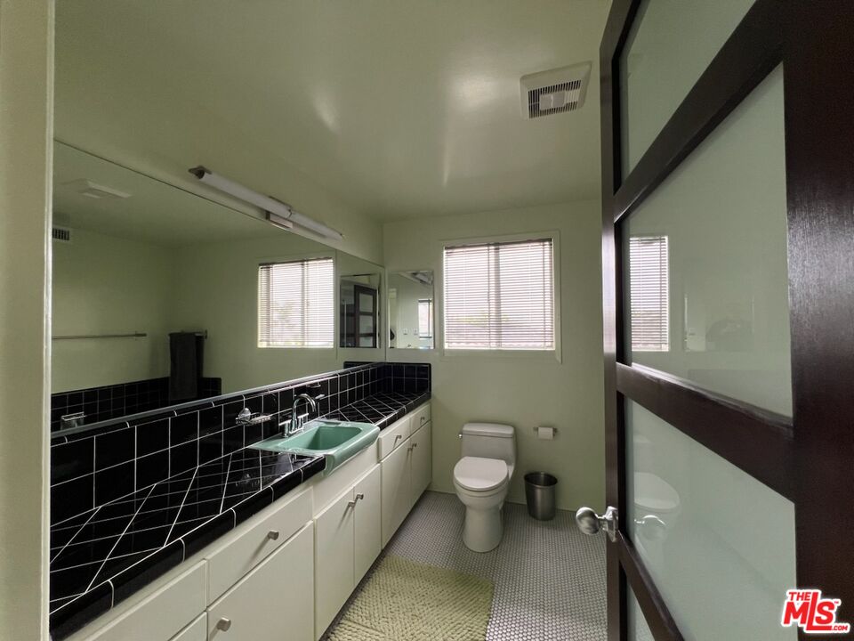254 Tranquillo Road Pacific Palisades, CA 90272 - Photo 9 of 16 a bathroom with a sink a mirror and a toilet