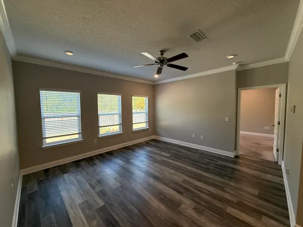 a view of wooden floor and a chandelier fan in a room