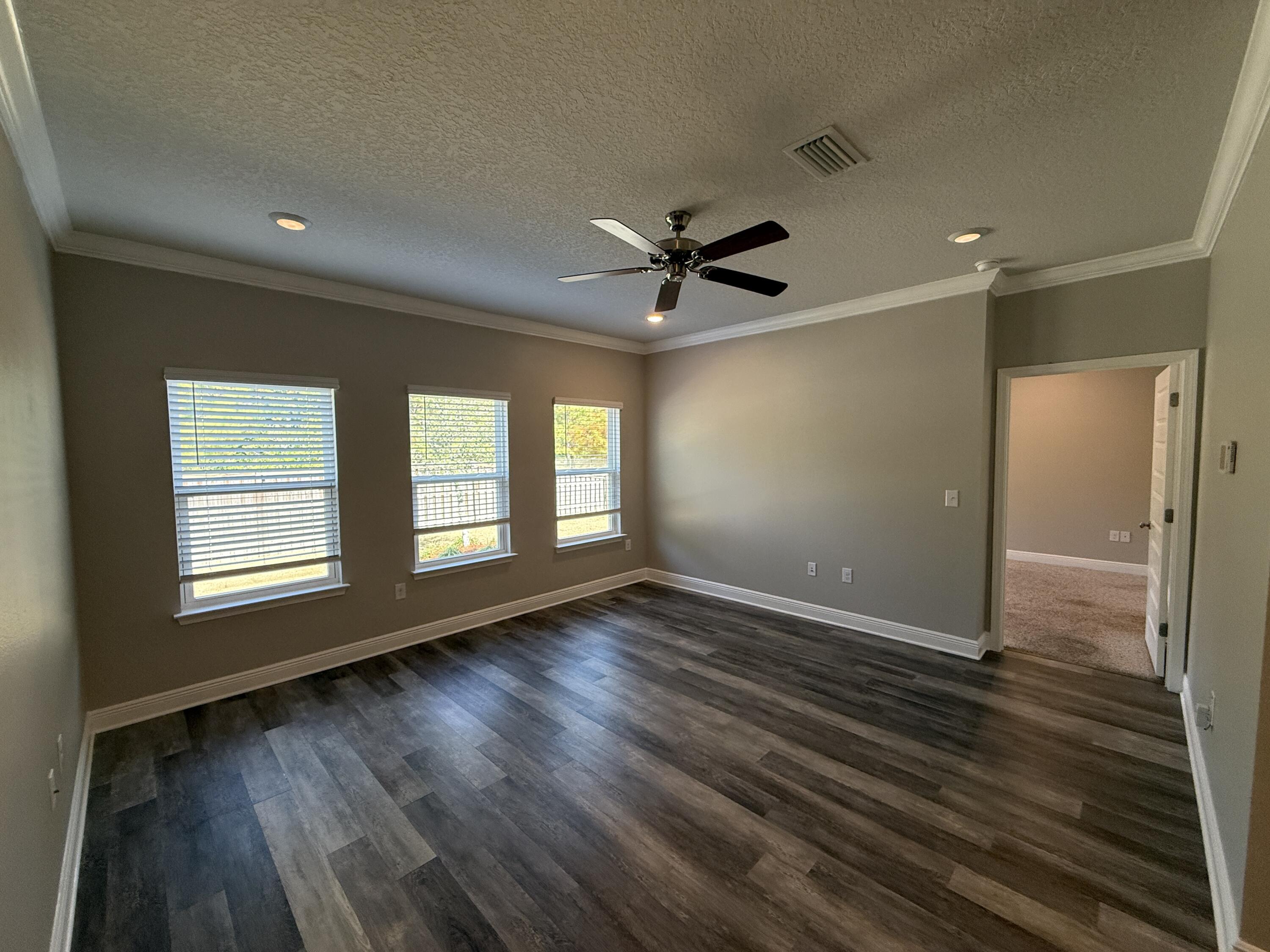 491 Lightning Bug Lane, Unit LOT 11 Freeport, FL 32439 - Photo 18 of 34 a view of wooden floor and a chandelier fan in a room