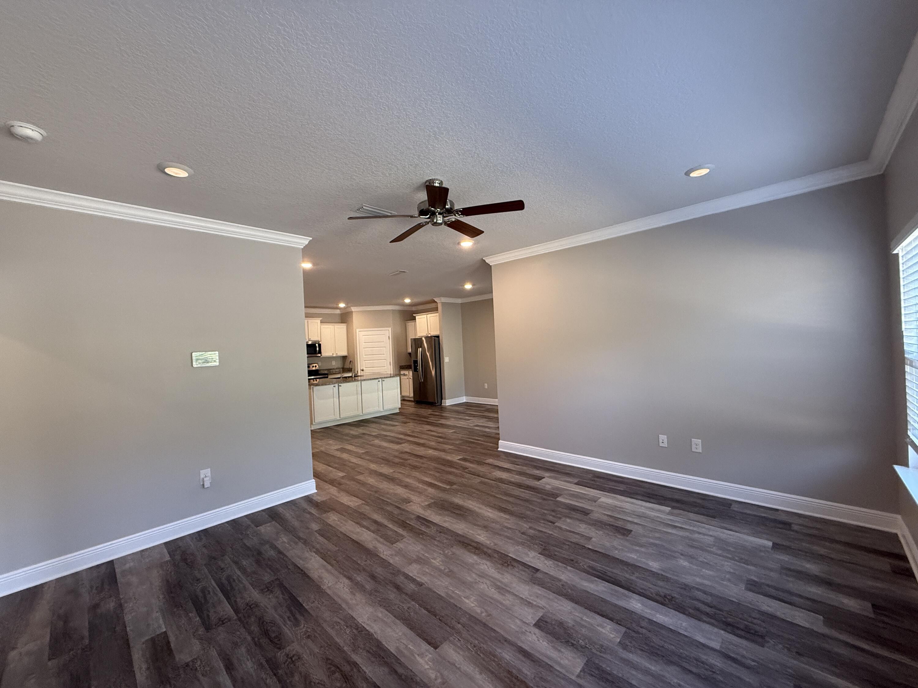 491 Lightning Bug Lane, Unit LOT 11 Freeport, FL 32439 - Photo 20 of 34 a view of a livingroom with wooden floor and a ceiling fan