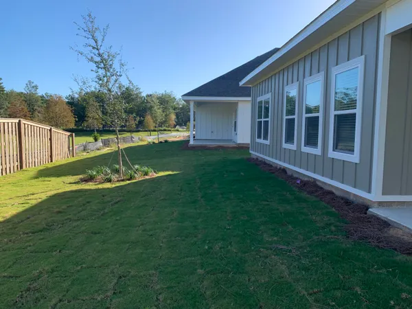a view of a house with backyard and sitting area