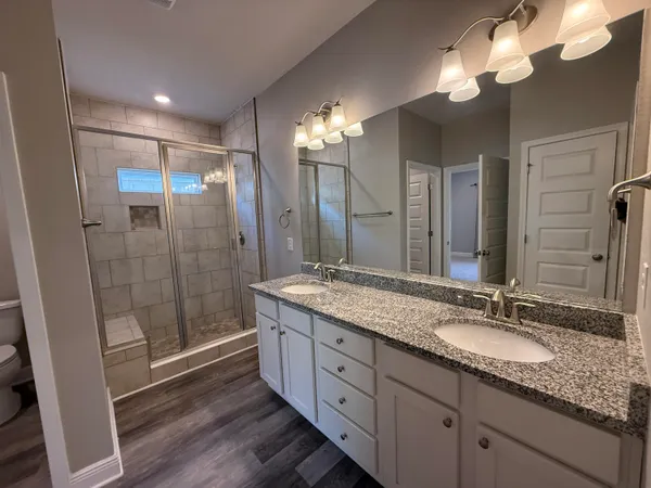 a bathroom with double vanity and a shower