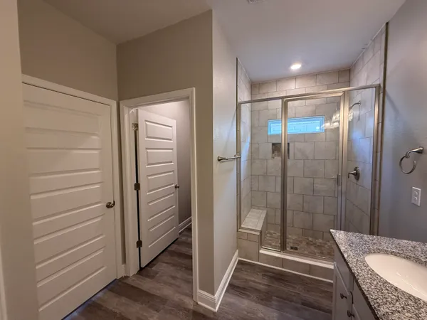a bathroom with a granite countertop shower and a sink