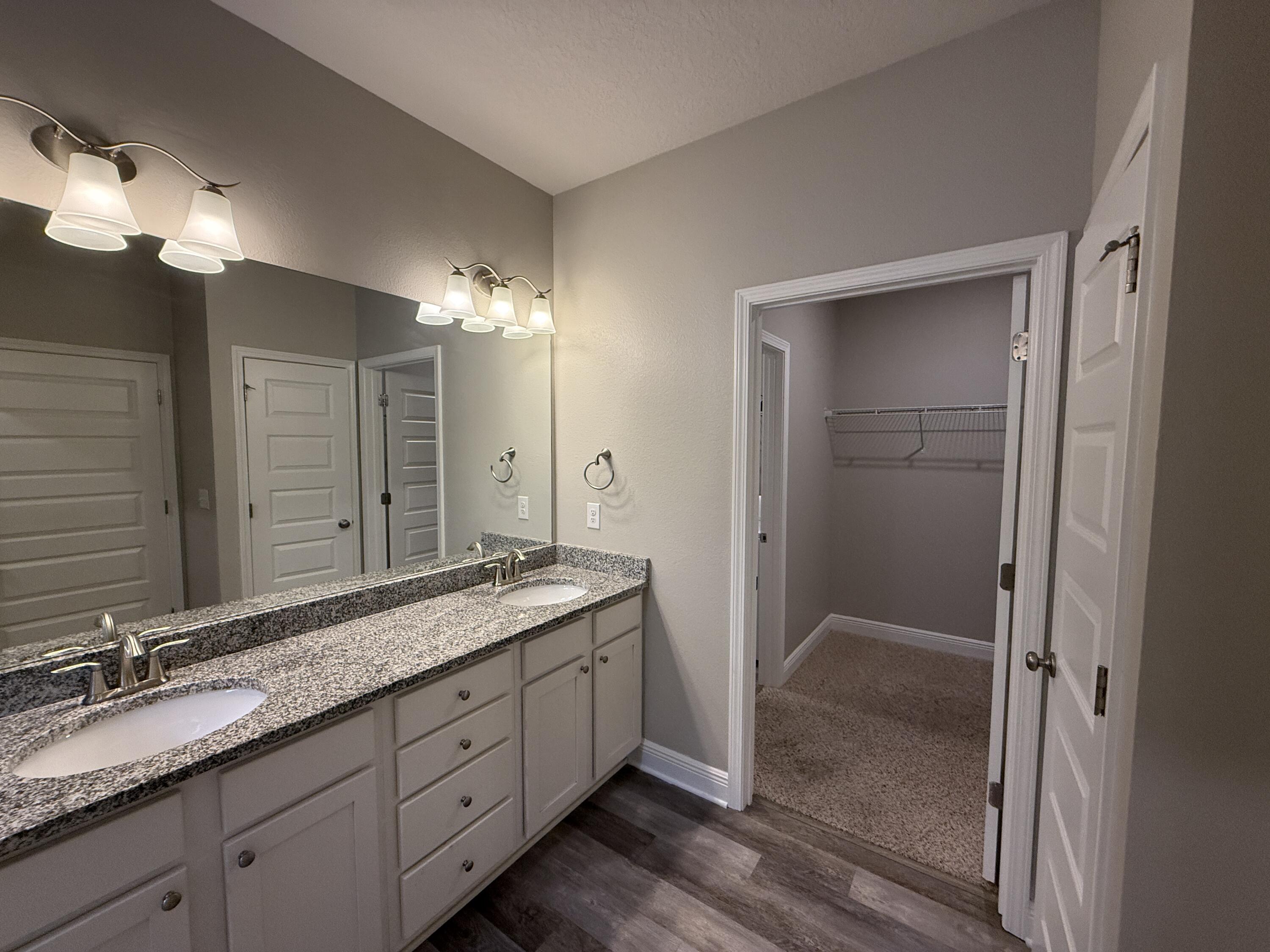 491 Lightning Bug Lane, Unit LOT 11 Freeport, FL 32439 - Photo 29 of 34 a bathroom with a granite countertop sink a large mirror and a shower