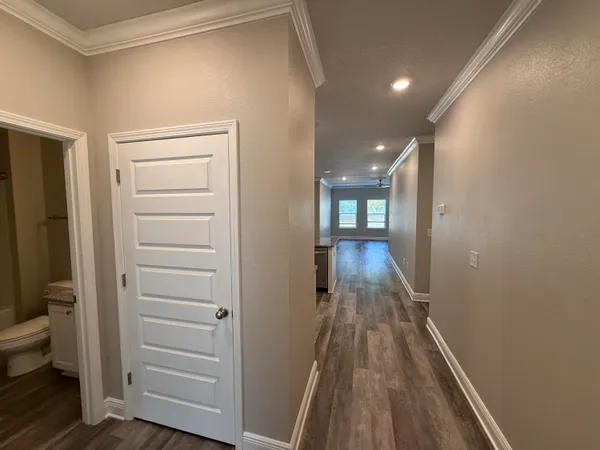 a view of a hallway with wooden floor and closet