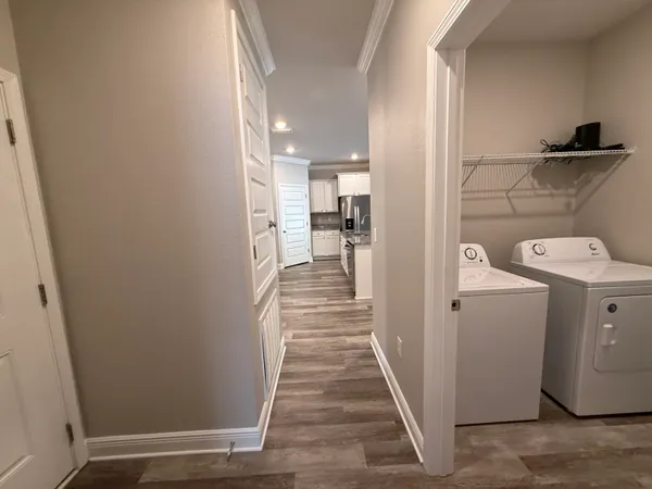a view of a hallway with wooden floor and closet