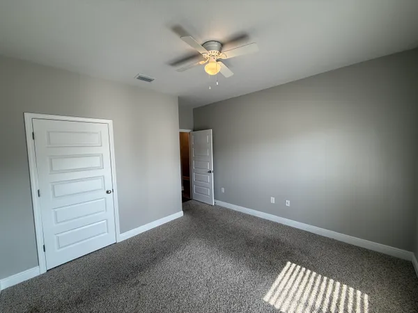 a view of an empty room with a ceiling fan