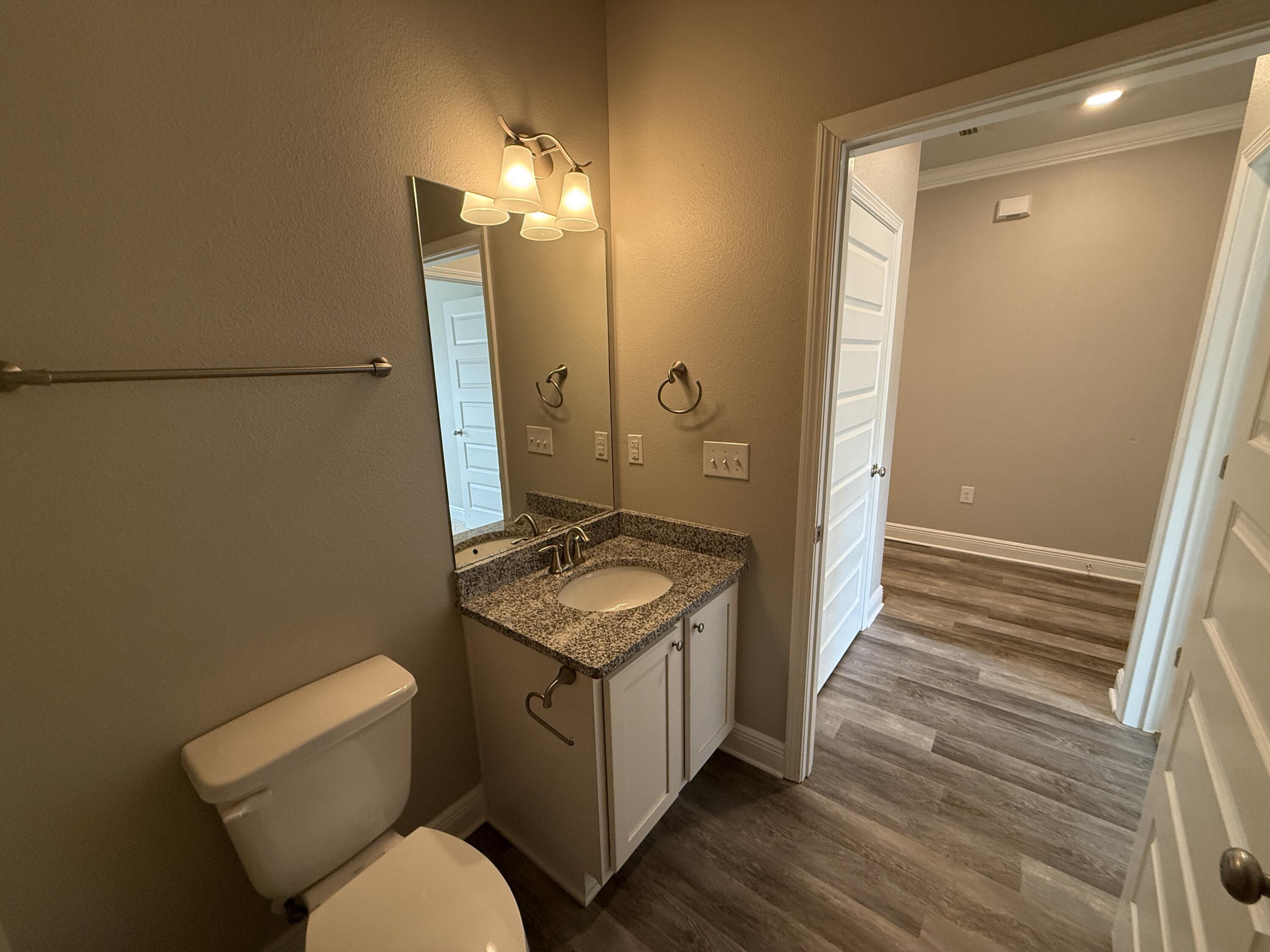 491 Lightning Bug Lane, Unit LOT 11 Freeport, FL 32439 - Photo 7 of 34 a bathroom with a granite countertop toilet a sink and a mirror
