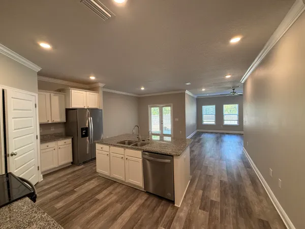 a kitchen with stainless steel appliances granite countertop a stove cabinets and wooden floor