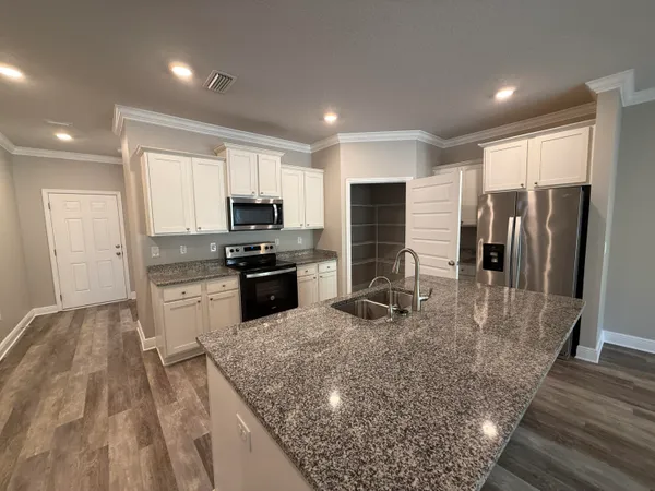 a kitchen with stainless steel appliances granite countertop a refrigerator sink and stove