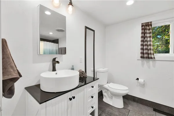a bathroom with a toilet sink and mirror