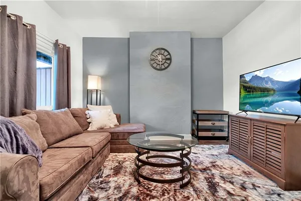 a living room with furniture a rug and a window