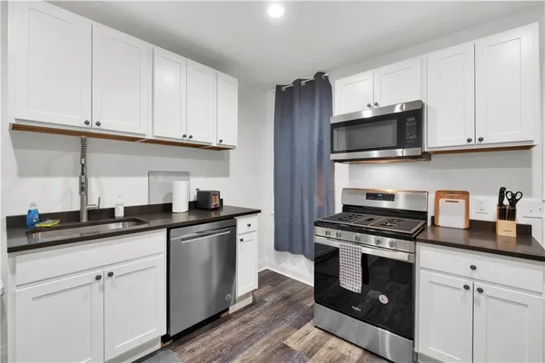 a kitchen with granite countertop a sink and cabinets