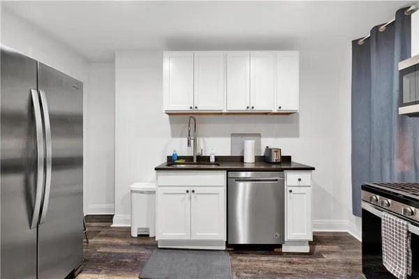 a kitchen with stainless steel appliances granite countertop a stove a refrigerator and a sink