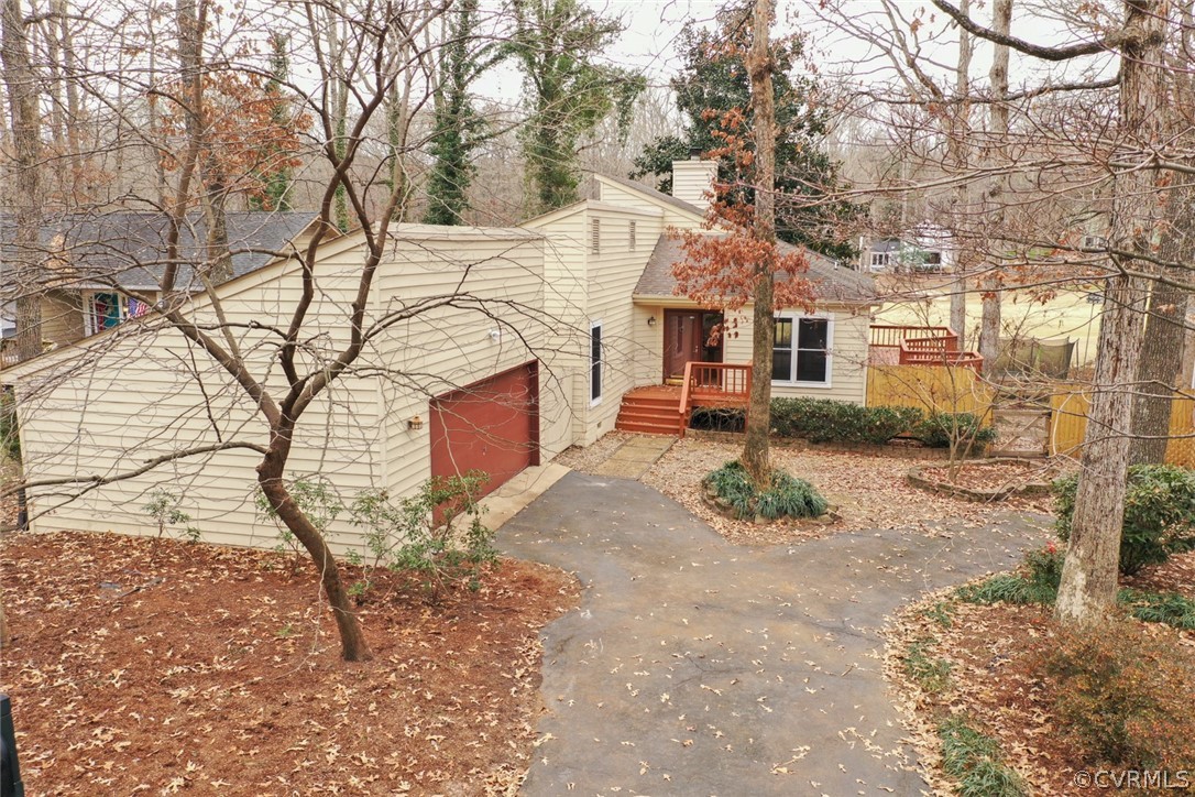 a backyard of a house with large trees and outdoor seating