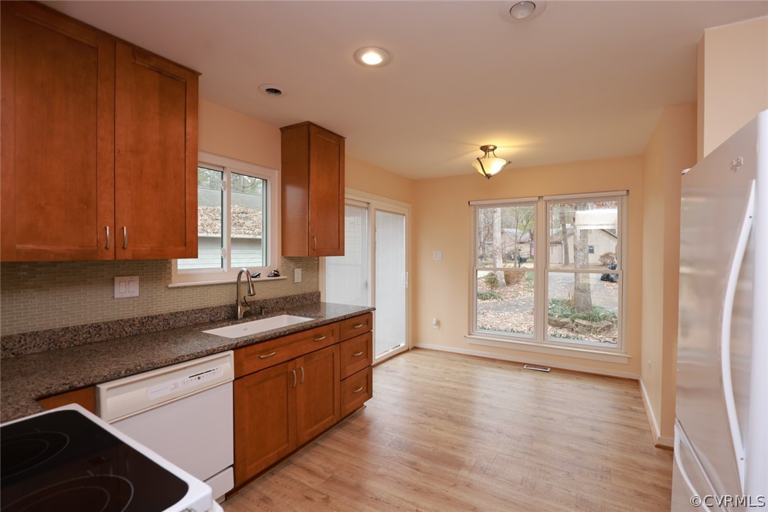 3024 3 Bridges Road Midlothian, VA 23112 - Photo 12 of 50 a kitchen with stainless steel appliances granite countertop a refrigerator a sink dishwasher and wooden cabinets with wooden floor