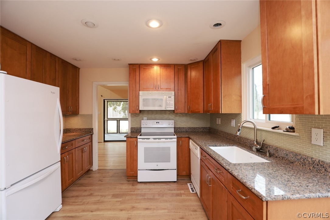 3024 3 Bridges Road Midlothian, VA 23112 - Photo 15 of 50 a kitchen with stainless steel appliances granite countertop a refrigerator a sink dishwasher a stove with wooden cabinets and floor