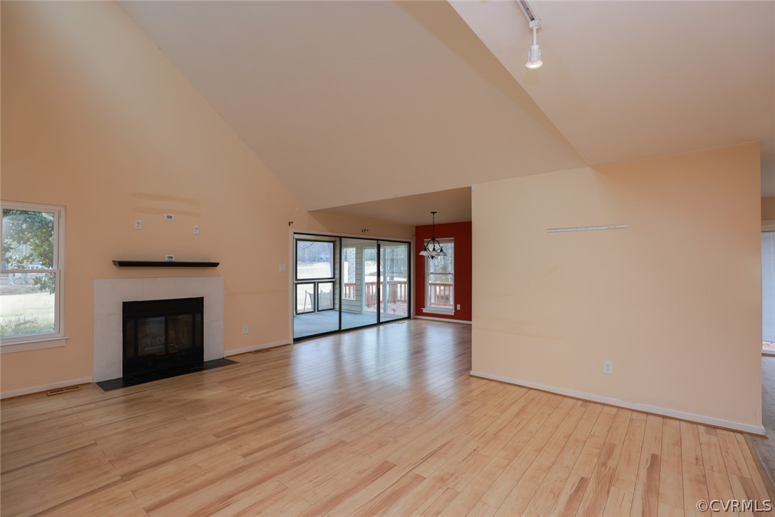 3024 3 Bridges Road Midlothian, VA 23112 - Photo 7 of 50 an empty room with wooden floor fireplace and windows