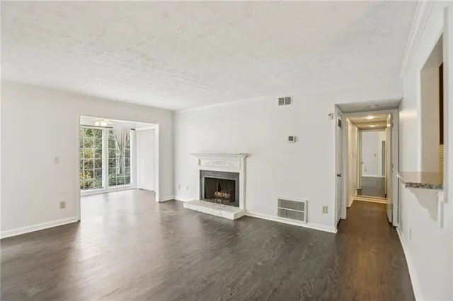 an empty room with wooden floor and bathroom view