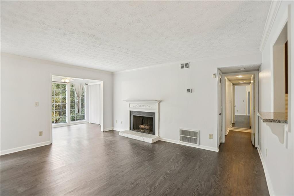 801 Countryside Place Smyrna, GA 30080 - Photo 3 of 34 an empty room with wooden floor fireplace and windows