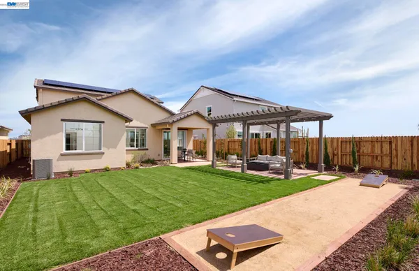 a view of a house with backyard and sitting area