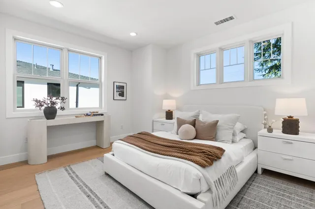 a bedroom with a bed and a potted plant