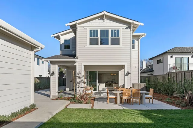 a view of a white house with a large windows and plants