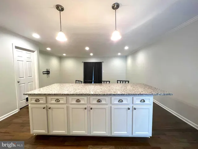 a kitchen with granite countertop a stove a sink and a wooden floors