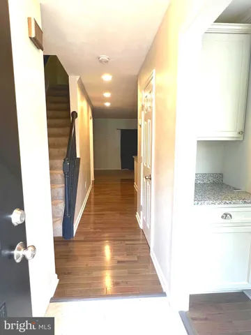 a view of a hallway with wooden floor and staircase