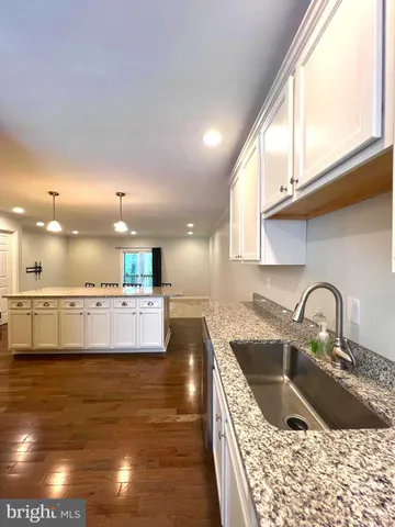 a kitchen with kitchen island a sink a stove and a window