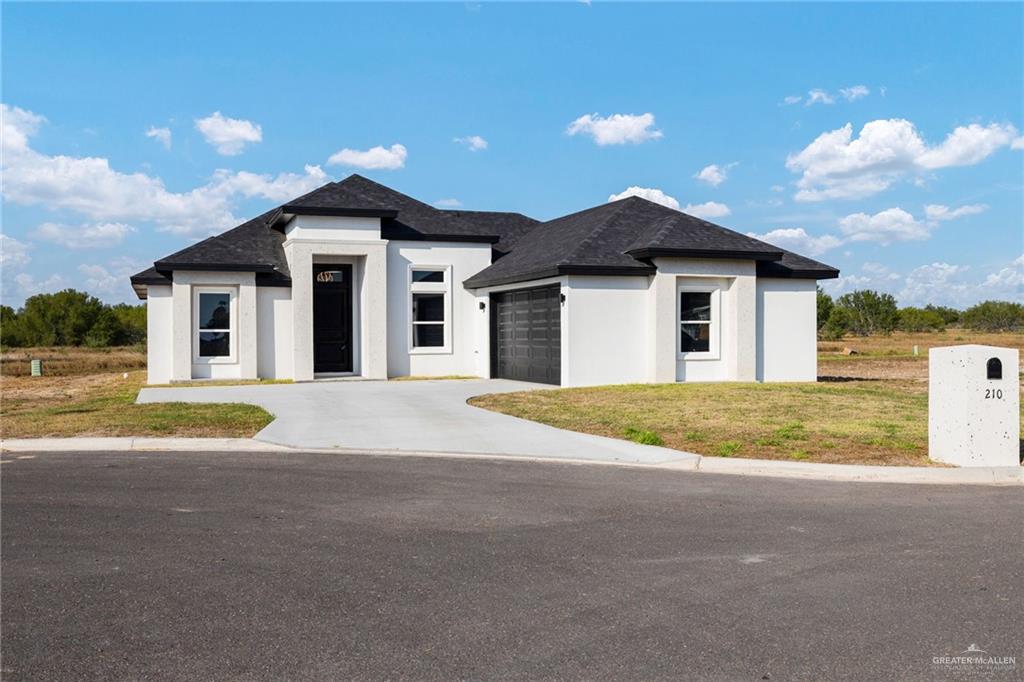 a view of yellow house with a yard and large trees