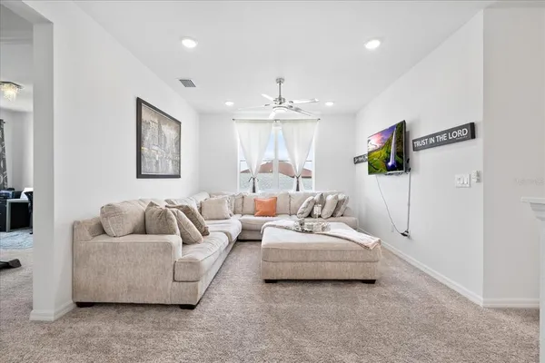 a living room with furniture and a ceiling fan