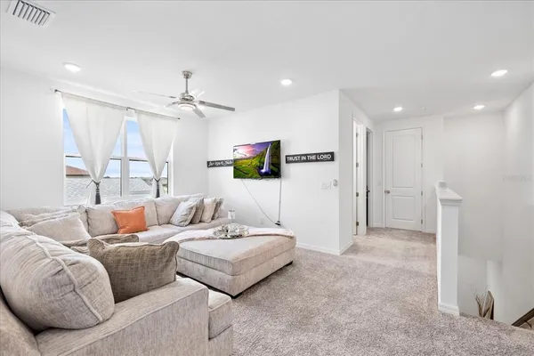 a living room with furniture couches and a dining table with wooden floor