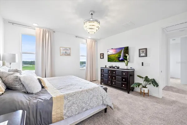 a bedroom with a bed and a chandelier