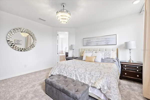 a bedroom with a bed and a chandelier