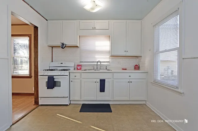 a kitchen with granite countertop white cabinets and white appliances