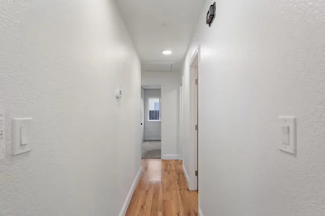 a view of a hallway with wooden floor