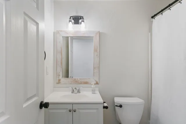a bathroom with a toilet sink and mirror