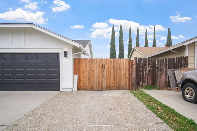 a view of a house with a yard and parking space