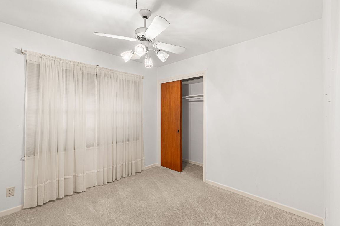 1800 Barbara Street Austin, TX 78757 - Photo 24 of 37 an empty room with a chandelier fan and closet area